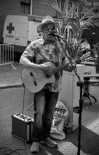Ein Straßenkünstler singt und spielt Gitarre. 